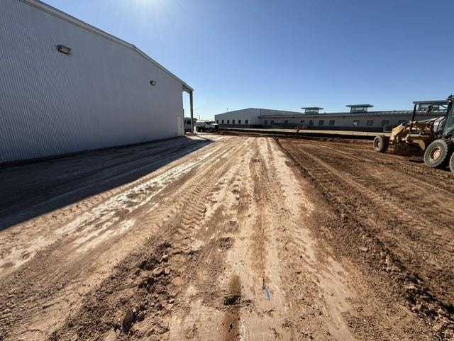 Grading and site prep with loader beside commercial metal building
