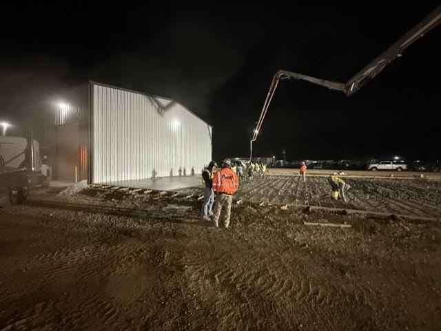 Nighttime concrete pour with pump truck and crew
